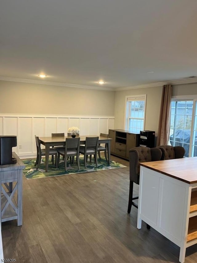 dining area with crown molding, dark hardwood / wood-style flooring, and a wealth of natural light