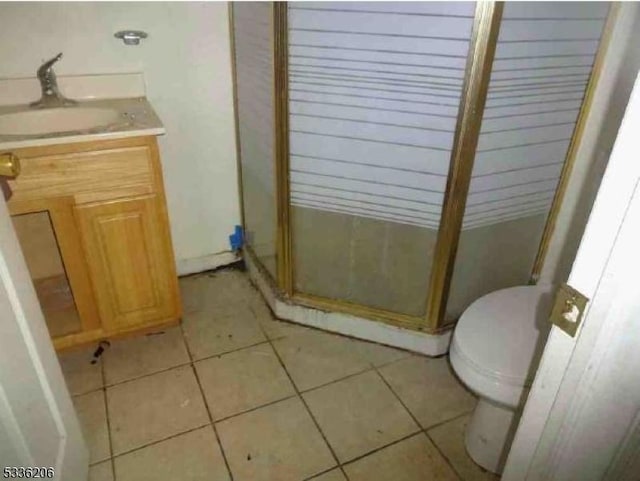 bathroom featuring tile patterned flooring, vanity, walk in shower, and toilet