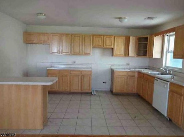 kitchen with light brown cabinetry, sink, light tile patterned floors, and dishwasher