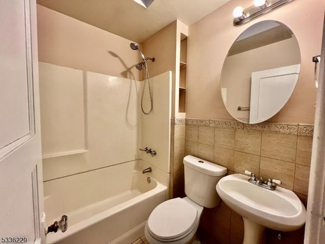 full bathroom with toilet, sink, shower / bathing tub combination, and tile walls