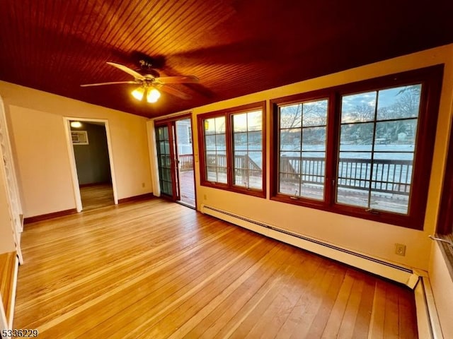 spare room featuring a baseboard heating unit, light hardwood / wood-style floors, a wall mounted AC, and ceiling fan