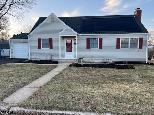 view of front of property featuring a chimney, solar panels, a shingled roof, and a front lawn