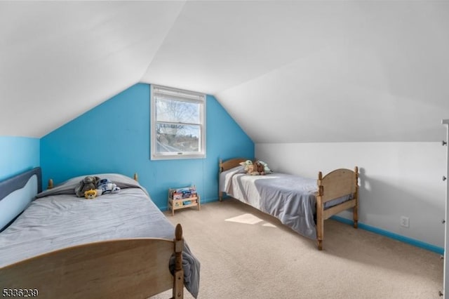 carpeted bedroom featuring baseboards and lofted ceiling