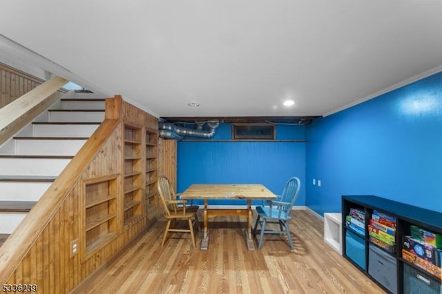 dining area with baseboards, wood finished floors, and stairs