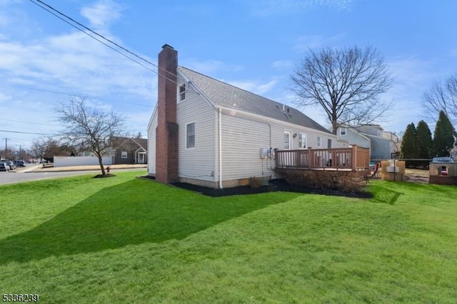 back of house with a deck, a yard, fence, and a chimney