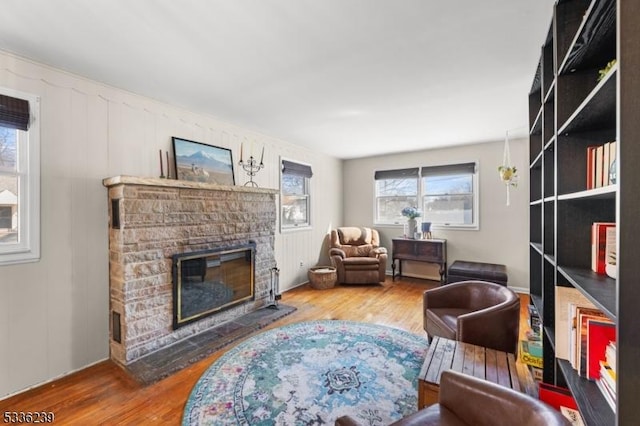 sitting room featuring wood finished floors, a decorative wall, and a fireplace