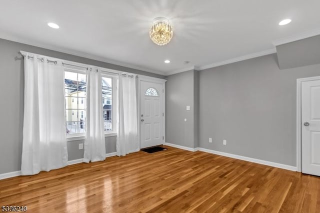 foyer entrance with hardwood / wood-style flooring and crown molding