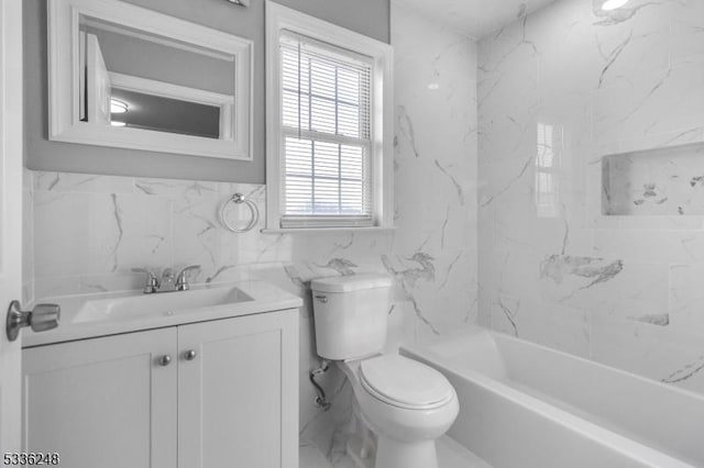 full bathroom featuring tiled shower / bath, vanity, toilet, and tile walls