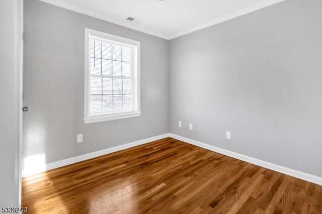 spare room with crown molding and hardwood / wood-style flooring