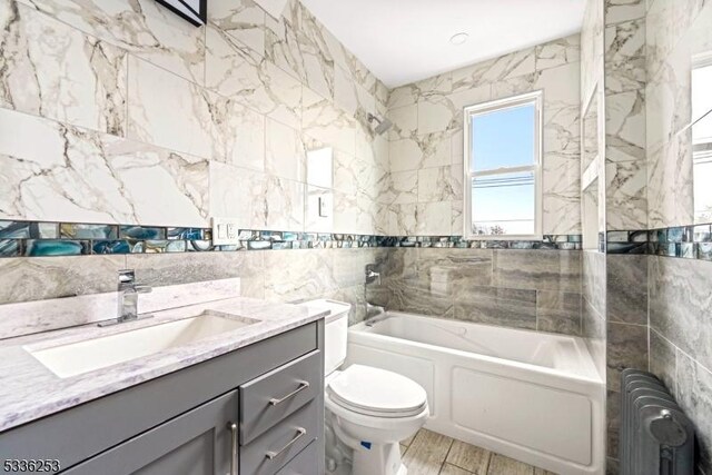 153-157 Stuyvesant Ave, Newark City, NJ 07106 - bathroom featuring radiator, tile walls, vanity, a bath, and toilet