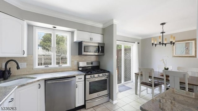 kitchen featuring light tile patterned flooring, an inviting chandelier, light stone counters, a sink, and stainless steel appliances