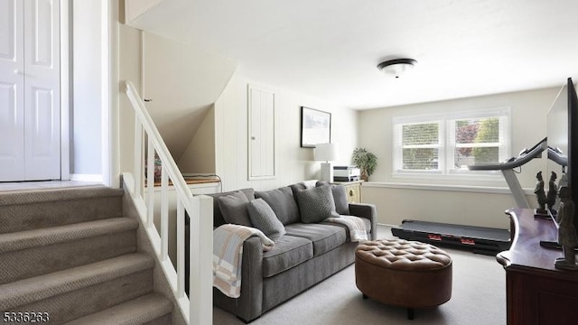 carpeted living room with stairway