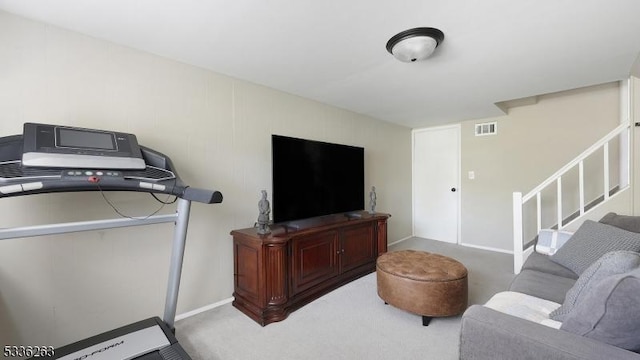 living room with visible vents, carpet, and stairway