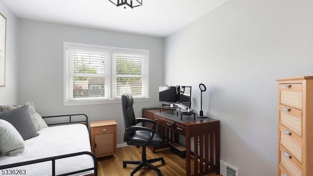 office area with baseboards, visible vents, and light wood-style flooring