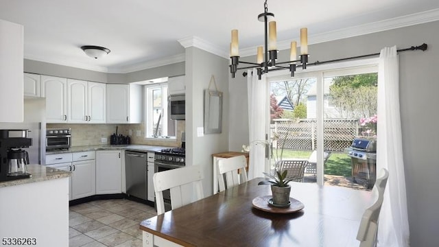 dining space featuring a notable chandelier, ornamental molding, and a toaster