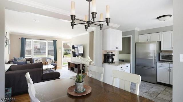 dining space with a toaster, ornamental molding, and a chandelier