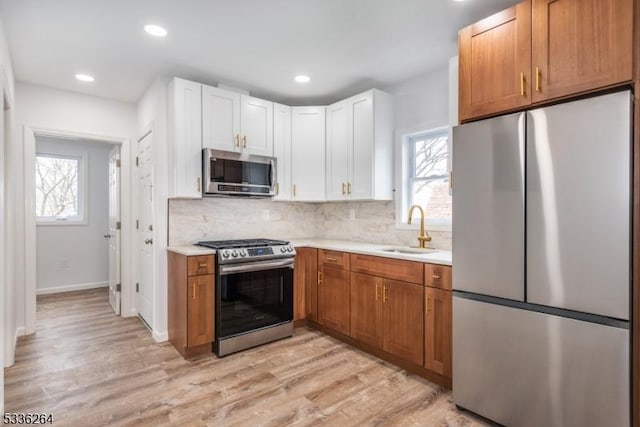 kitchen featuring sink, a wealth of natural light, white cabinets, and appliances with stainless steel finishes