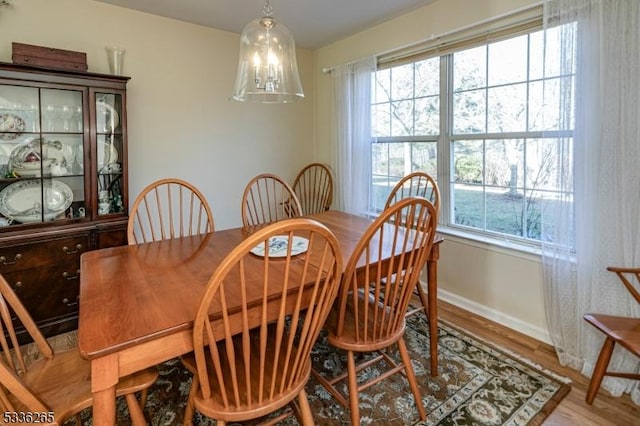 dining space with hardwood / wood-style flooring and a notable chandelier