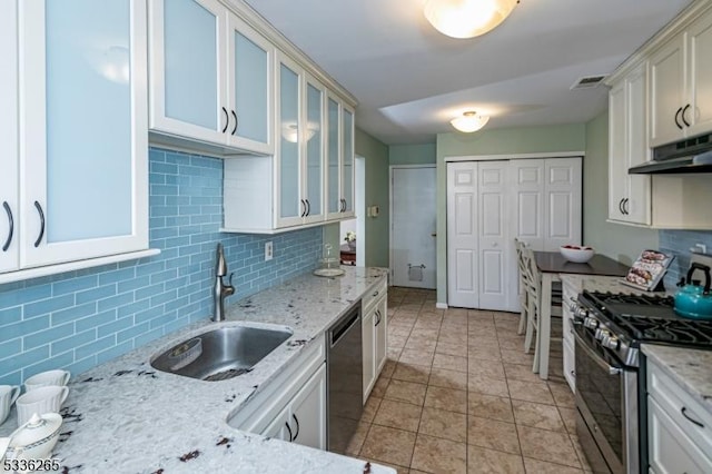 kitchen with light stone counters, sink, and appliances with stainless steel finishes