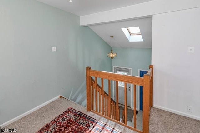 stairway with lofted ceiling with skylight, carpet floors, and a chandelier