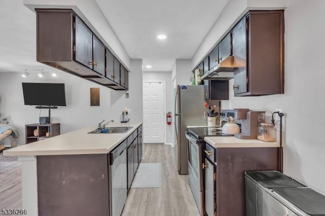 kitchen with a breakfast bar, sink, kitchen peninsula, stainless steel appliances, and light hardwood / wood-style flooring