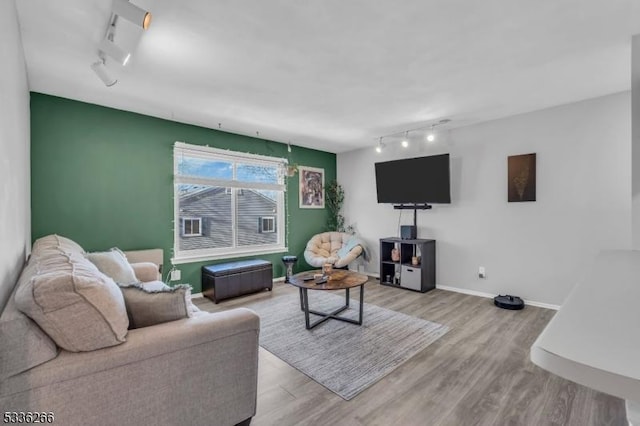 living room with light hardwood / wood-style flooring and rail lighting