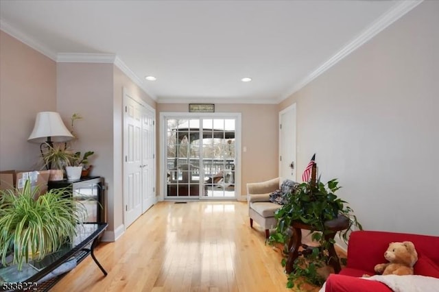 living area with hardwood / wood-style flooring and ornamental molding