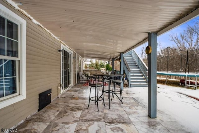 snow covered patio with a trampoline