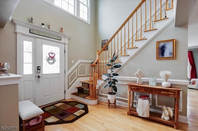 foyer entrance featuring a high ceiling and light hardwood / wood-style flooring