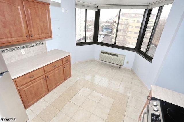 kitchen with tasteful backsplash, a wall mounted AC, and light tile patterned floors