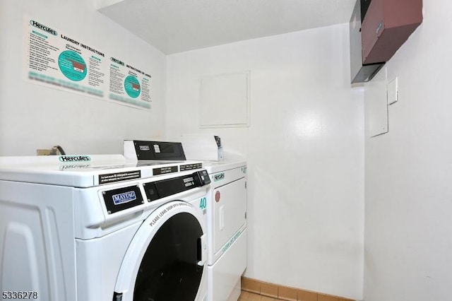 laundry area featuring washing machine and dryer and light tile patterned floors