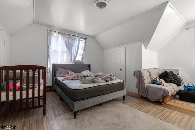 bedroom featuring wood-type flooring and vaulted ceiling