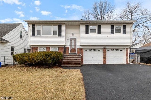 bi-level home featuring a garage and a front lawn