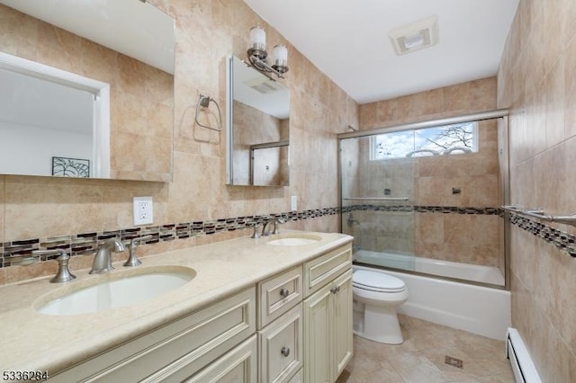 full bathroom with a baseboard radiator, tile walls, vanity, and shower / bath combination with glass door