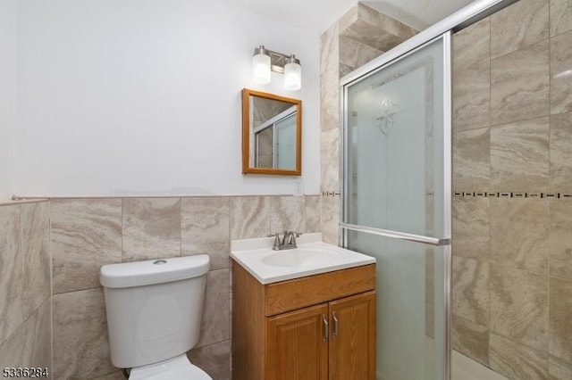 bathroom featuring vanity, tile walls, an enclosed shower, and toilet