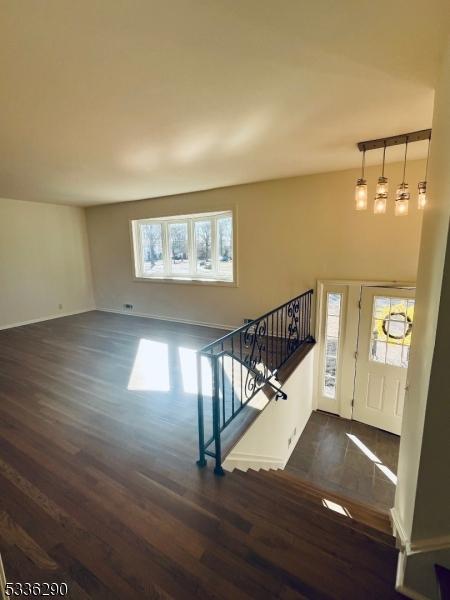 entrance foyer featuring dark wood-style floors and stairs