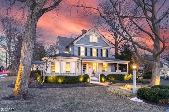 view of front of house featuring a porch and a chimney