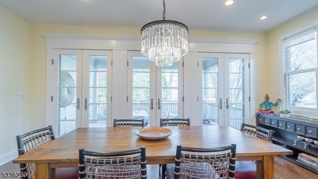 dining space featuring plenty of natural light, a chandelier, and french doors