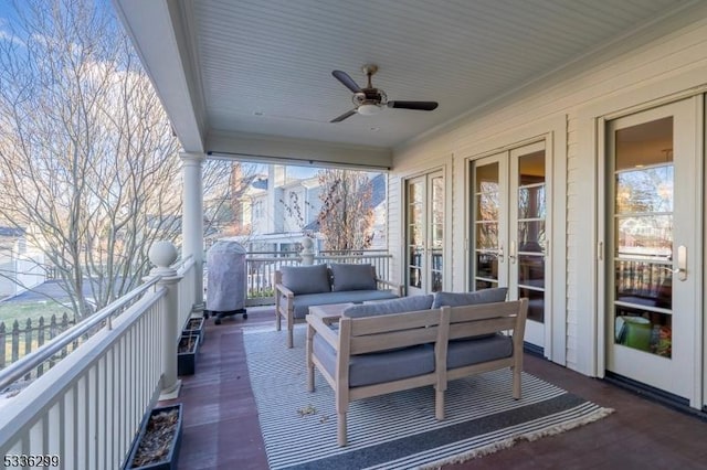 wooden terrace featuring ceiling fan and an outdoor living space