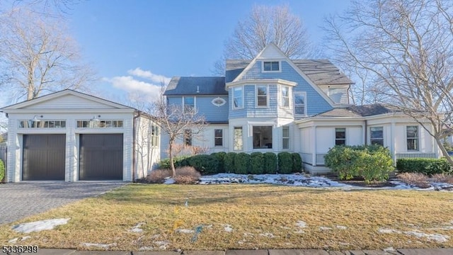 view of front facade with a garage, aphalt driveway, and a front lawn