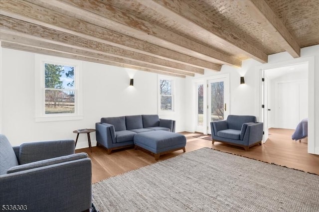 living room featuring beamed ceiling and wood finished floors