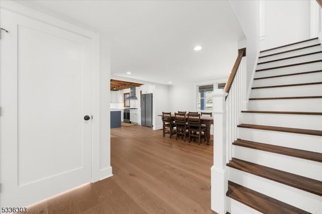 staircase with recessed lighting and wood finished floors