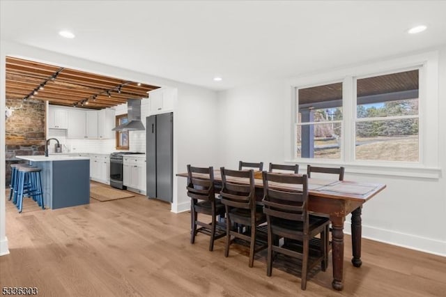 dining room featuring recessed lighting, baseboards, and light wood finished floors