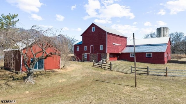 view of barn with a yard and fence