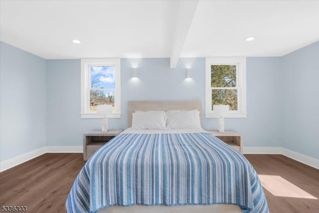 bedroom with multiple windows, baseboards, and wood finished floors