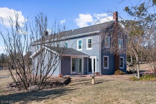 back of house featuring a lawn and a chimney