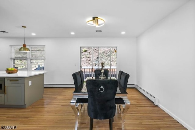 dining room featuring a baseboard radiator and light wood-type flooring