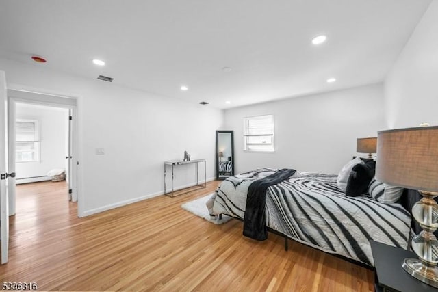 bedroom featuring light hardwood / wood-style floors and baseboard heating