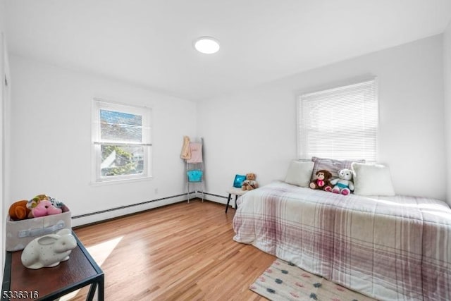 bedroom featuring hardwood / wood-style floors and baseboard heating