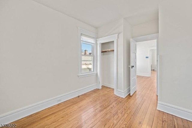 unfurnished bedroom featuring light hardwood / wood-style flooring and a closet